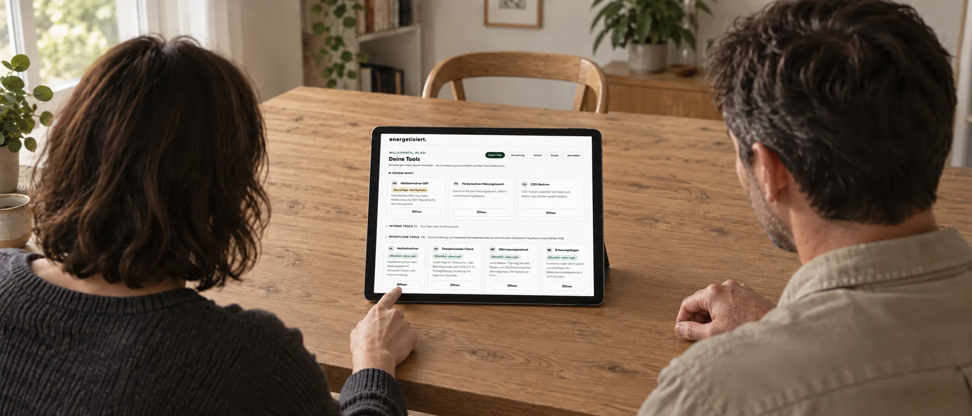 Paar von hinten am Esstisch, auf dem Tablet die Online-Rechner von energetisiert