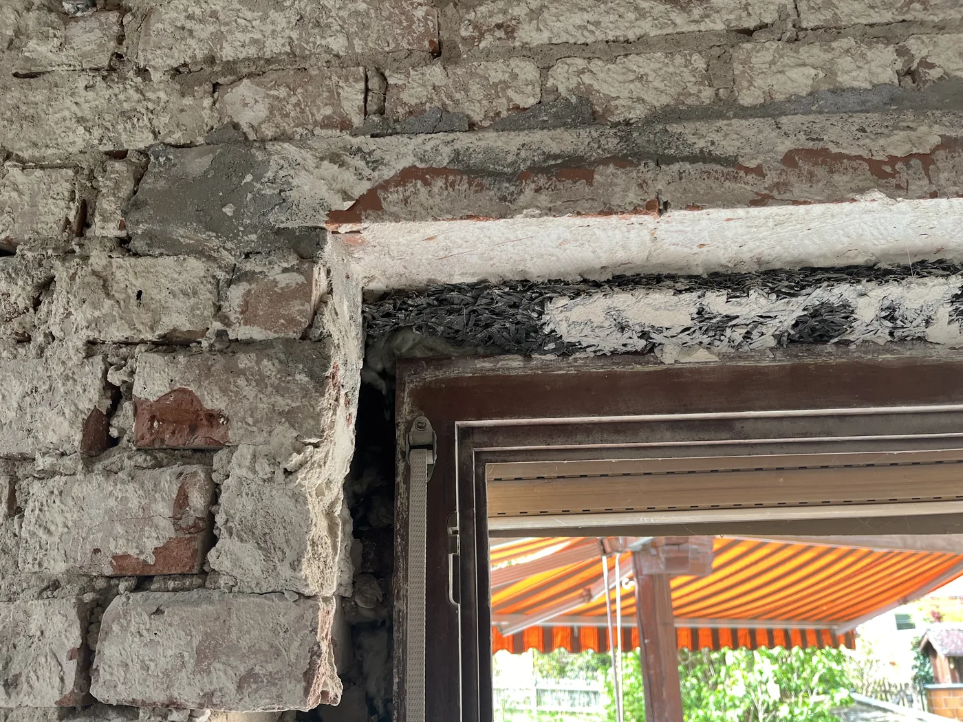 Fensteranschluss von außen mit schadhaftem Putz rund um den Rahmen